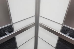 FSRT732 Внутренняя часть лифта Levele-103 с верхними панелями из нержавеющей стали с отделкой из морского камня; нижние панели из клееного алюминия с темной патиной и узором Чарльстон; большие панели из вивихромового хромового стекла с белой прослойкой и Forms-surfaces 