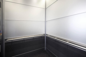 FSRT750 Интерьер лифта Levele-104 с захватными панелями из стекла vivichrome chromis с белой прослойкой и отделкой opalex, клееный алюминий с темной патиной и рисунком ustin, нержавеющая сталь с отделкой seastone; круглые поручни в павильоне амбулаторной